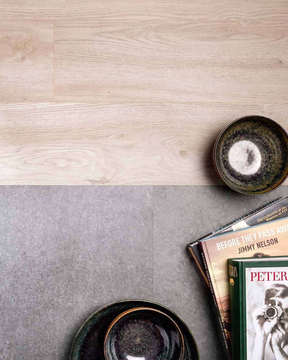 Vue de détail d'une transition horizontale en douceur entre des dalles vinyles effet pierre grise et des planches vinyles effet bois de chêne.